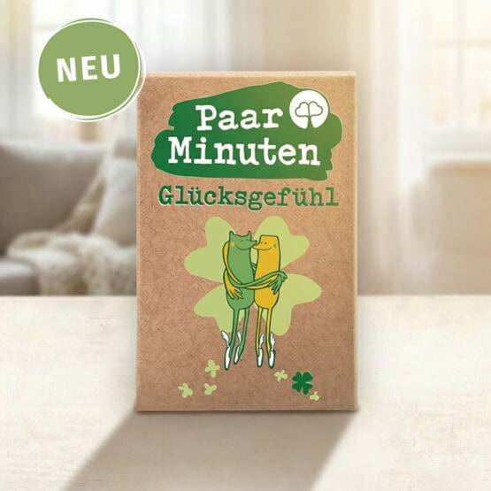 Paarzeit PaarMinuten Glücksgefühl NEU – Kartenset mit 53 Gesprächsimpulsen zu Beziehungsglück und Lebensfreude, Box mit grünem Logo auf Tisch mit Sofa im Hintergrund