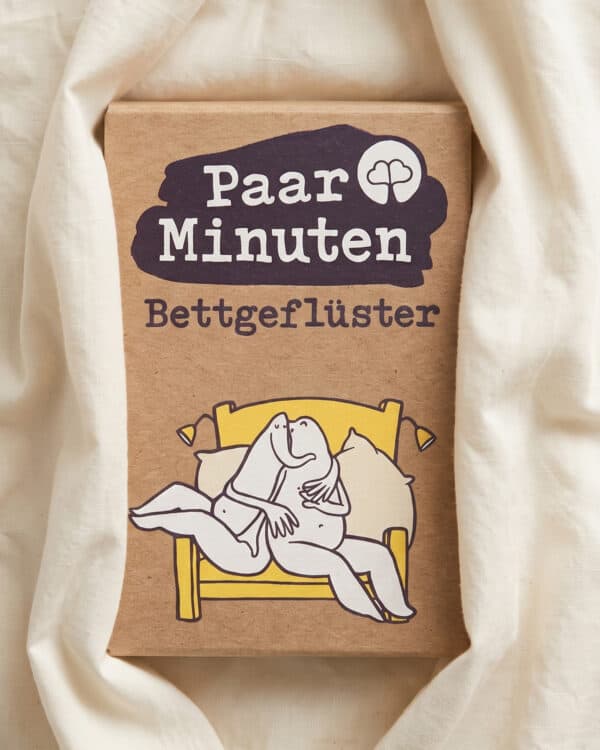 Schachtel PaarMinuten Bettgeflüster auf weißer Bettwäsche, auf der Verpackung ein illustriertes Paar in einem gelben Bett