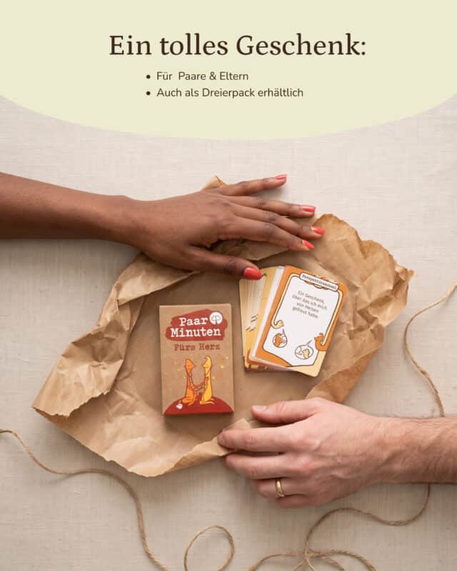 Zwei Hände legen die Schachtel PaarMinuten Fürs Herz und einen Stapel Fragekarten auf zerknittertes Kraftpapier, daneben liegt Paketschnur