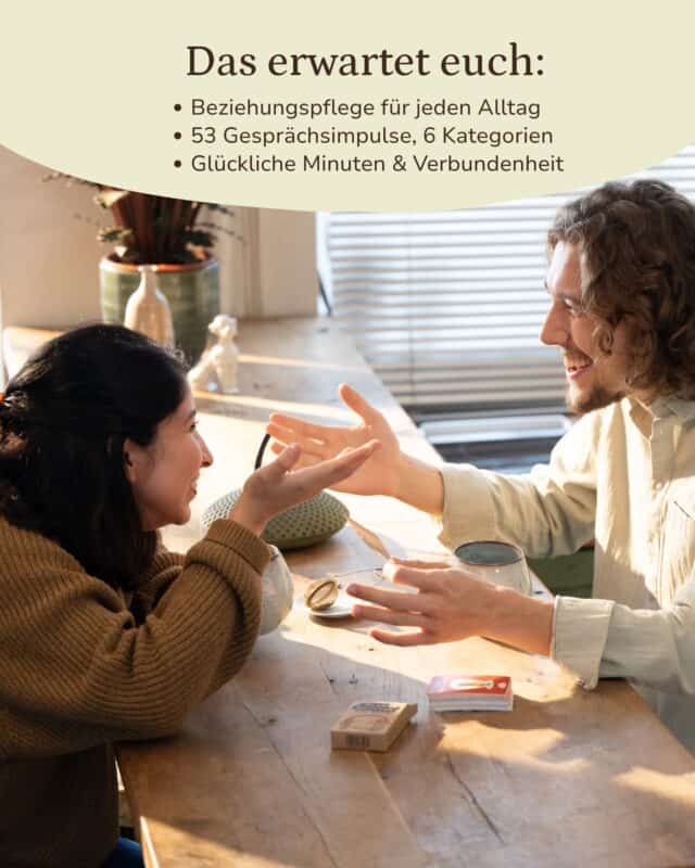 Frau und Mann sitzen sich an einem sonnigen Holztisch am Fenster gegenüber, lachen und strecken die Hände zueinander aus; vor ihnen liegen die Kraftpapier-Schachtel und ein Kartenstapel. Eingeblendet: „Das erwartet euch: Beziehungspflege für jeden Alltag · 53 Gesprächsimpulse, 6 Kategorien · Glückliche Minuten & Verbundenheit“