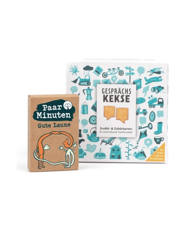 Die Kraftpapier-Schachtel PaarMinuten Gute Laune steht links neben der quadratischen weißen Schachtel der Gesprächskekse mit türkisen Illustrationen. Aufgedruckt: „Erzähl- & Zuhörkarten für unterhaltsame Familienzeiten“ und „Für 2 oder mehrere Erwachsene“.