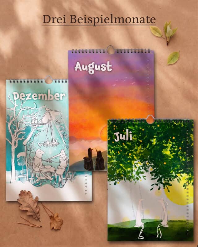 Drei Kalenderblätter mit Spiralbindung auf Kraftpapier zwischen Herbstlaub: Dezember mit winterlicher Zeichnung, August mit Sonnenuntergang am Meer und Juli mit einer Schaukel unter einem Baum