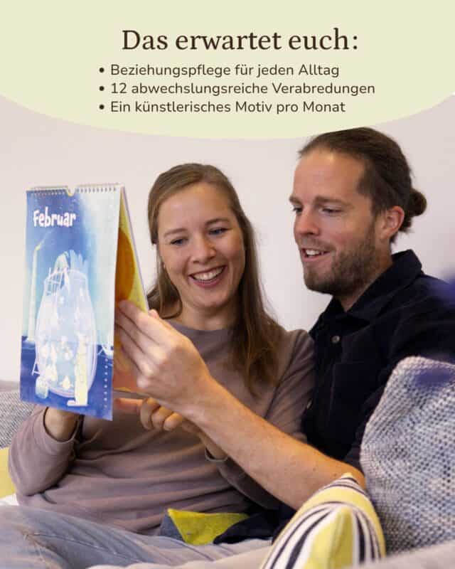 Eine Frau hält lachend das blaue Februar-Kalenderblatt mit illustriertem Motiv hoch, neben ihr sitzt ein Mann im dunklen Cordhemd auf dem Sofa und schaut mit ihr darauf. Eingeblendet: „Das erwartet euch: Beziehungspflege für jeden Alltag · 12 abwechslungsreiche Verabredungen · Ein künstlerisches Motiv pro Monat“