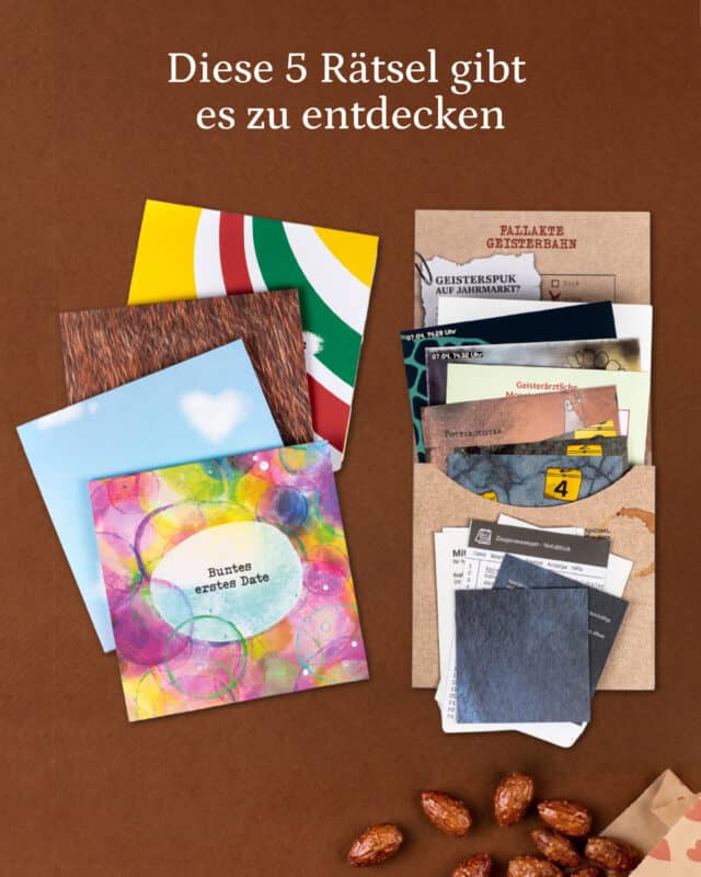 Fünf farbige Rätselumschläge des Spiels ZusammenSpiel liegen aufgefächert auf braunem Untergrund, daneben eine Kraftpapiermappe „Fallakte Geisterbahn“ mit Dokumenten und Spurenkarten