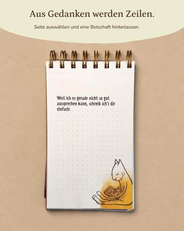 Der aufgeschlagene PaarZeilen-Block liegt von oben fotografiert auf sandfarbenem Papier, oben die goldene Spiralbindung. Auf der cremeweißen Seite steht in dunkler Schrift „Weil ich es gerade nicht so gut aussprechen kann, schreib ich’s dir einfach:“, darunter ist die Fläche mit einem feinen Punkteraster zum Schreiben frei. Rechts unten sitzt eine gezeichnete Katze mit geschlossenen Augen vor einem gelben Aquarellfleck und schreibt in ein kleines Heft. Eingeblendet oben in einer hellen Welle: „Aus Gedanken werden Zeilen.“ · „Seite auswählen und eine Botschaft hinterlassen.“