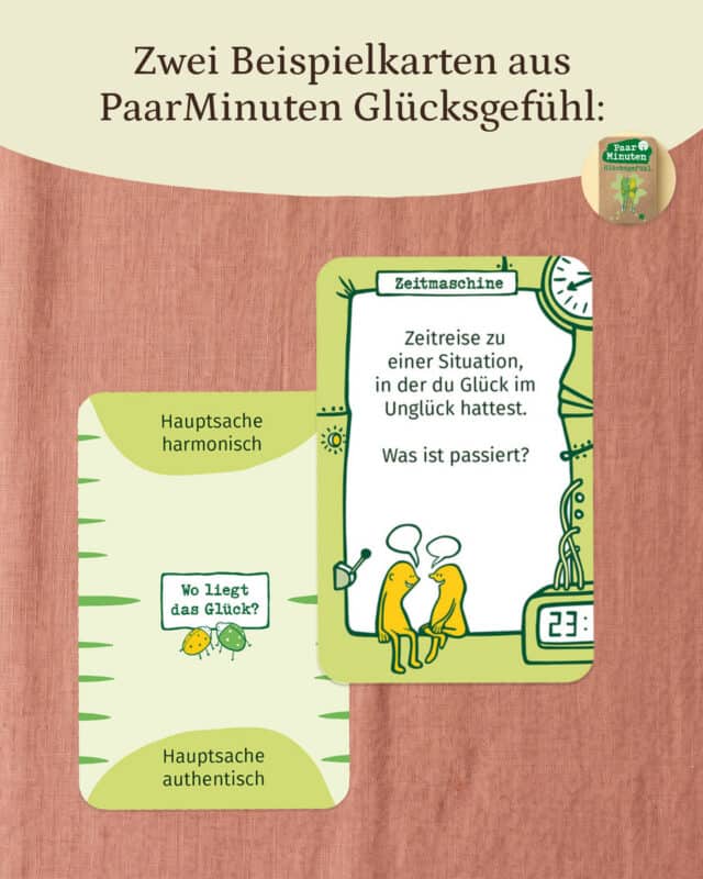 Zwei Fragekarten aus PaarMinuten Glücksgefühl auf altrosa Leinen: eine hellgrüne Karte „Wo liegt das Glück?“ mit den Polen „Hauptsache harmonisch“ und „Hauptsache authentisch“ und eine grüne Karte „Zeitmaschine“ mit „Zeitreise zu einer Situation, in der du Glück im Unglück hattest. Was ist passiert?“. Oben rechts ein rundes Bild der Schachtel. Eingeblendet: „Zwei Beispielkarten aus PaarMinuten Glücksgefühl:“